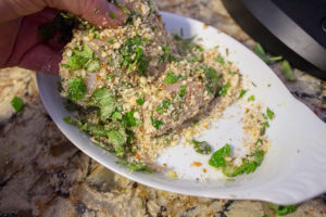 coating chicken breast with almond and herbs