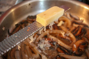 grating cheese into pan