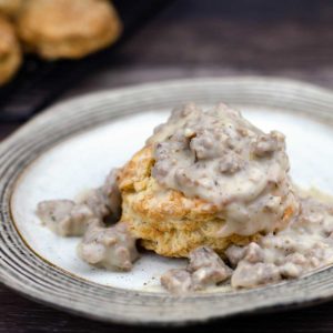 Sausage gravy on top of a biscuit on a plate