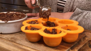 Ninja Foodi Chocolate Cake filling being scooped into a silicone tray