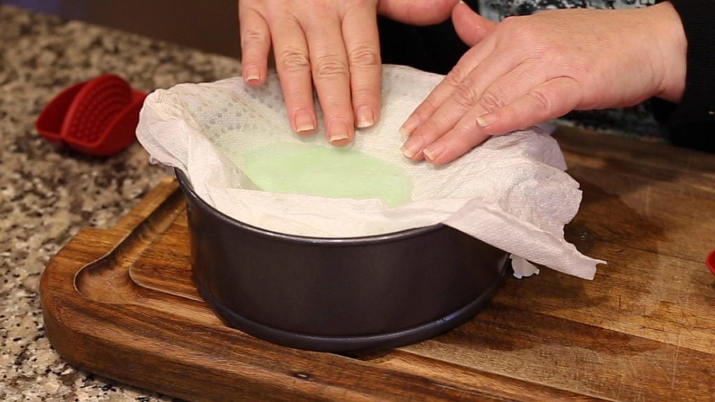 Mint Cheesecake in the Ninja Foodi paper towel absorbing moisture from the top of the cheesecake
