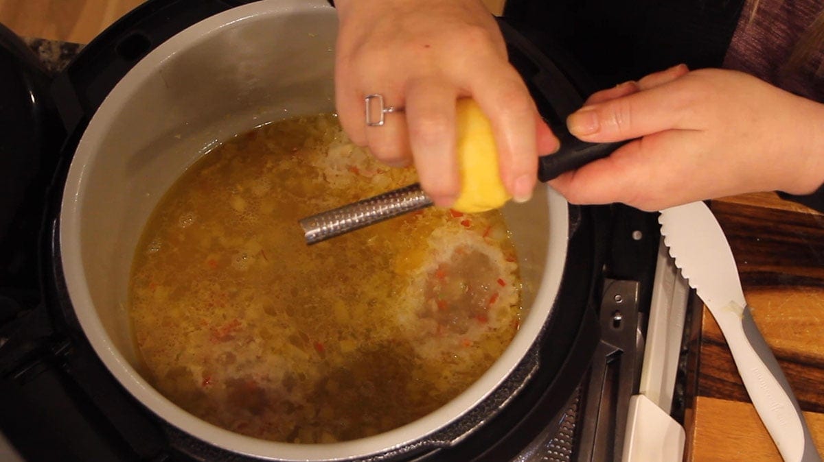 Zesting a lemon into the pot of shrimp scampi