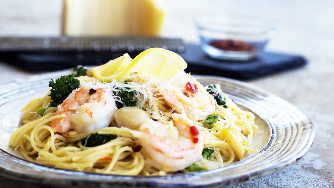 Shrimp Scampi on a plate with a lemon wedge on top