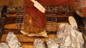 Cheesy meatloaf on rack applying the glaze