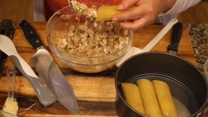 Stuffing the Mexican Manicotti shells with filling