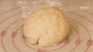 deep dish pizza dough sitting on pastry mat