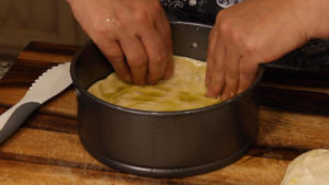 forming the deep dish pizza dough in a springform pan