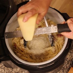 Grating cheese over the Ninja Foodi pot