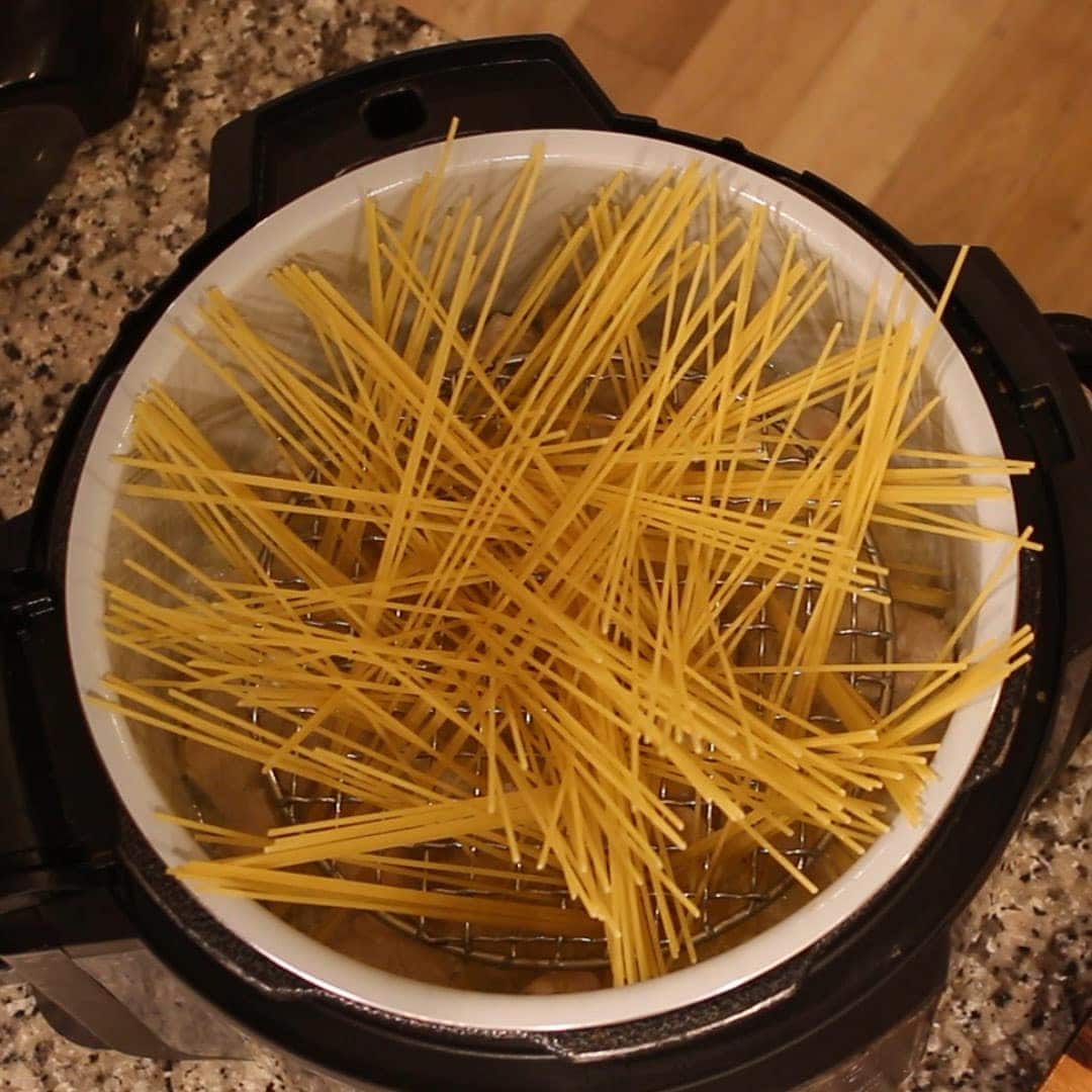 whole spaghetti noodles fanned out in the inner pot for making chicken carbonara