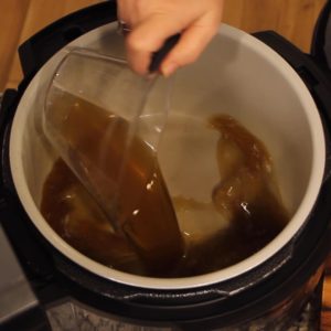 pouring jasmine tea into the inner pot of the Ninja Foodi