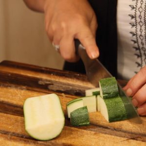 cutting large zucchini chunks for pasta primavera