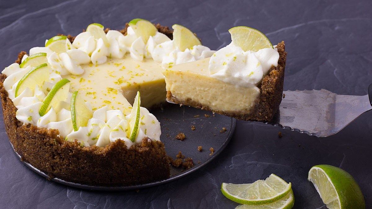A slice of key lime pie being removed from the pan