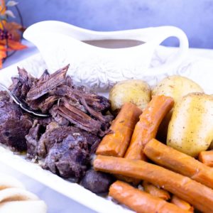 Pot roast on a platter with carrots and potatoes