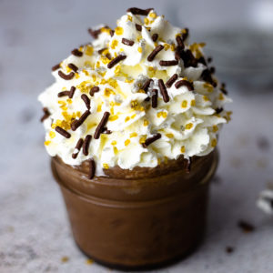 Chocolate Pot De Creme in a small canning jar with whipped cream and sprinkles