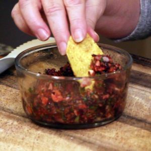 dipping a chip into cranberry salsa