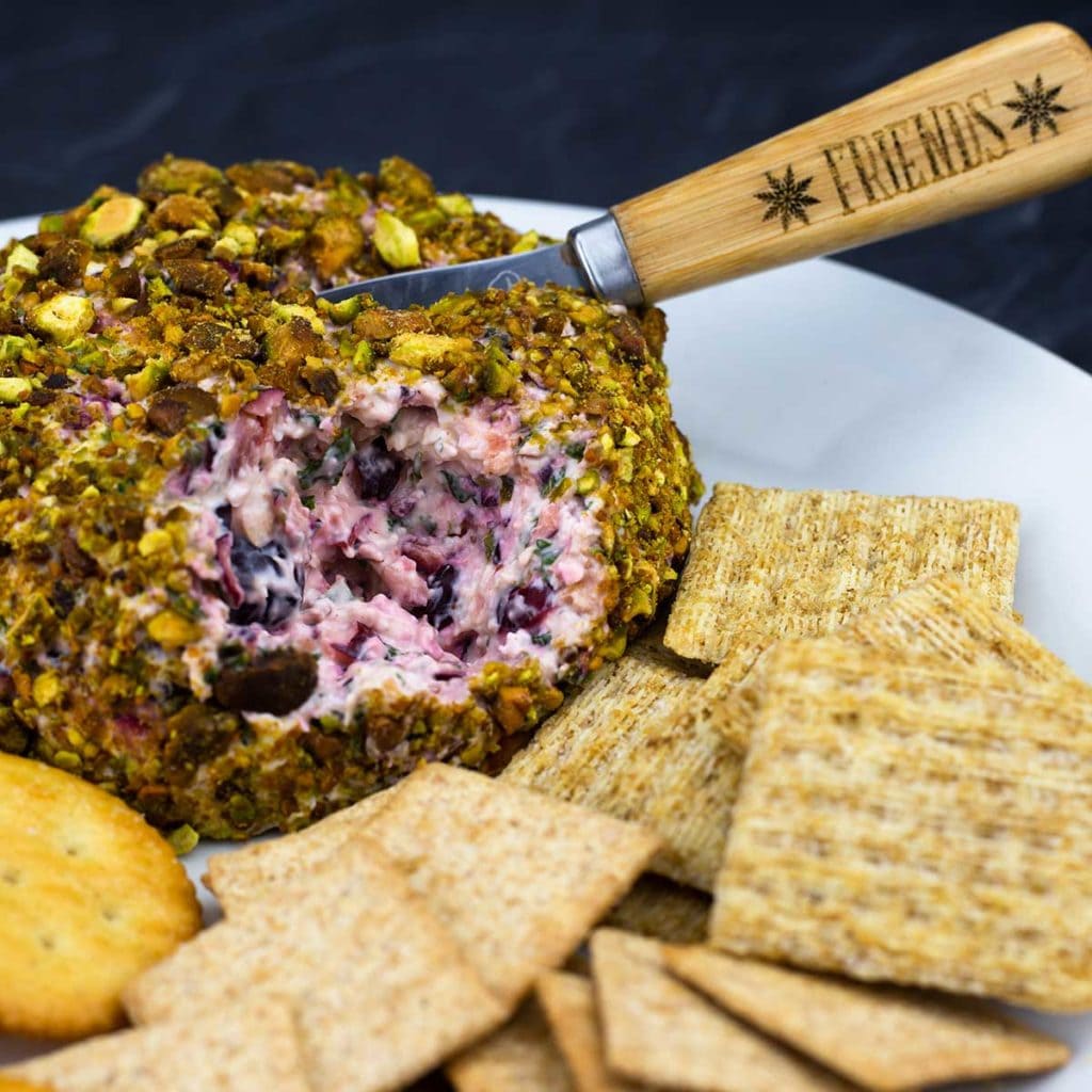 cranberry cheese ball on a plate with crackers