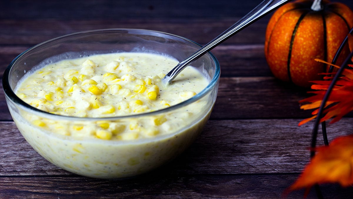 Cream Corn in a glass bowl with a serving spoon