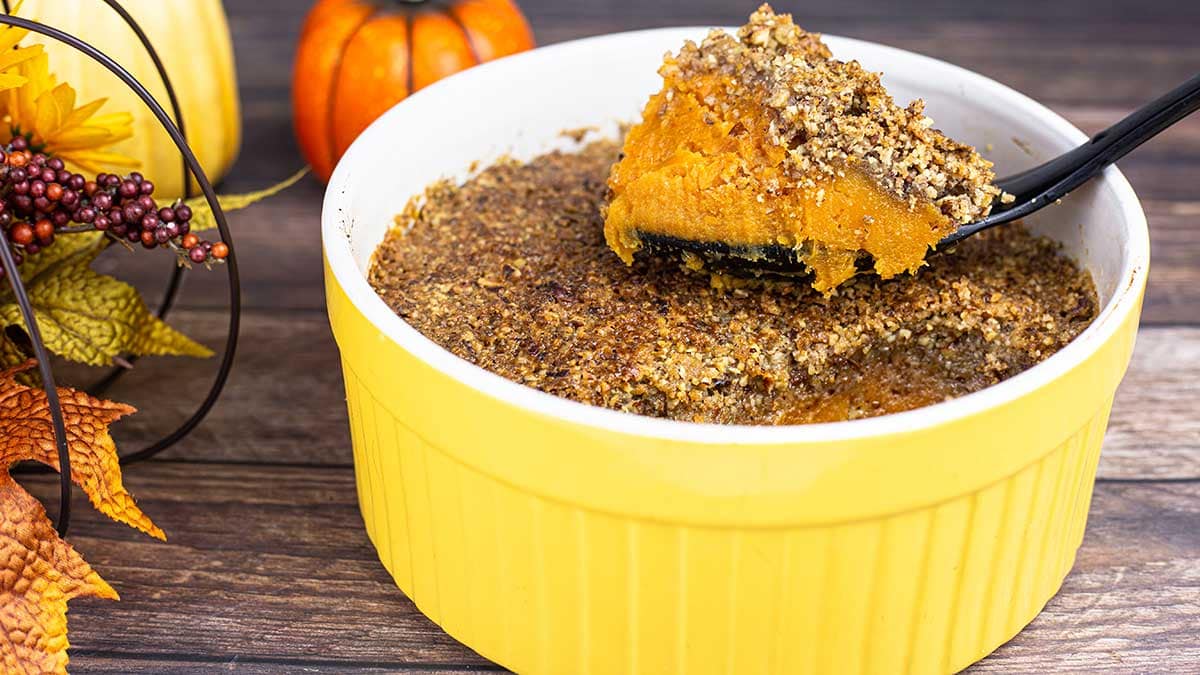 Sweet Potato Casserole with a pecan topping in a yellow serving dish