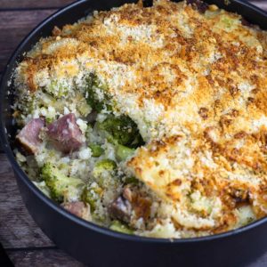 Ham and Broccoli Casserole with a scoop taken out in a black casserole dish