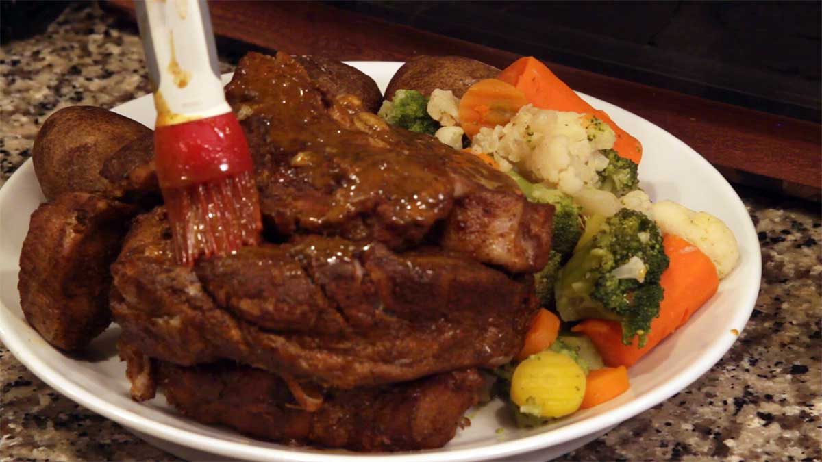 Country Style pork ribs with potatoes and veggies on a serving platter