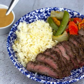 Asian steak 360 meal plated with peanut sauce in a bowl next to it