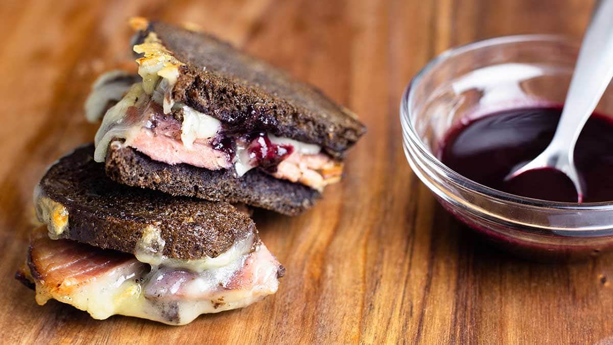 Ham & Brie Grilled Cheese cut sitting next to blueberry bbq sauce