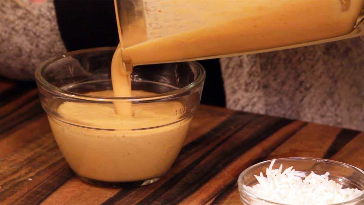 pouring homemade peanut sauce into a bowl for serving
