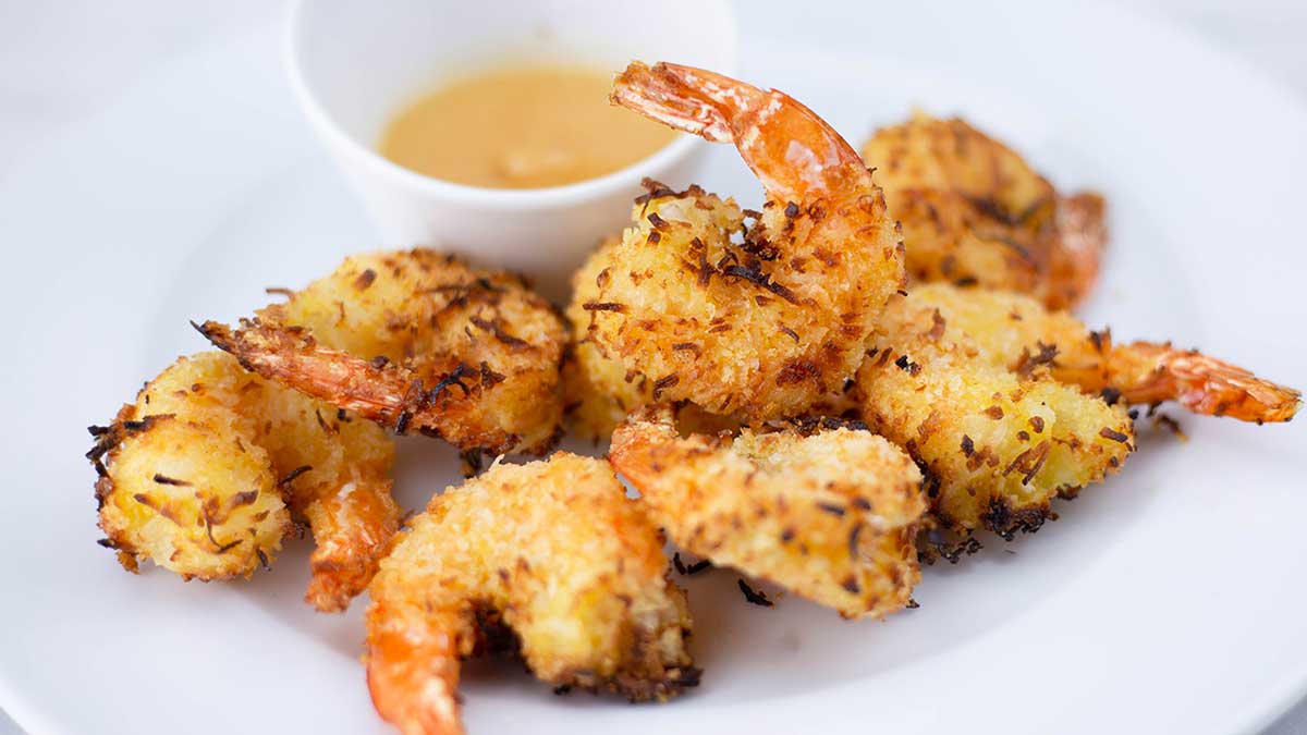 Air Fryer Coconut Shrimp on a plate with pineapple dipping sauce