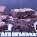 Homemade fudgy brownies stacked on a cooling rack
