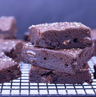 Homemade fudgy brownies stacked on a cooling rack