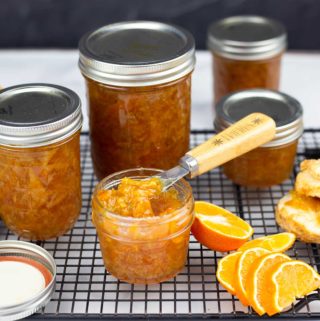 Orange Marmalade in jars with one open and biscuits beside it