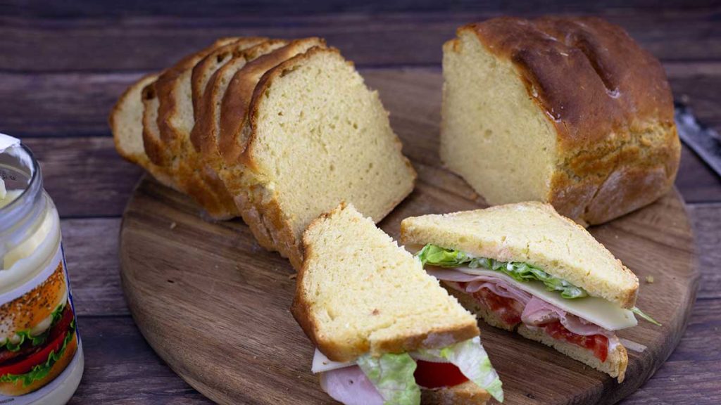 Sliced bread with a Ham & Swiss Sandwich on a cutting board