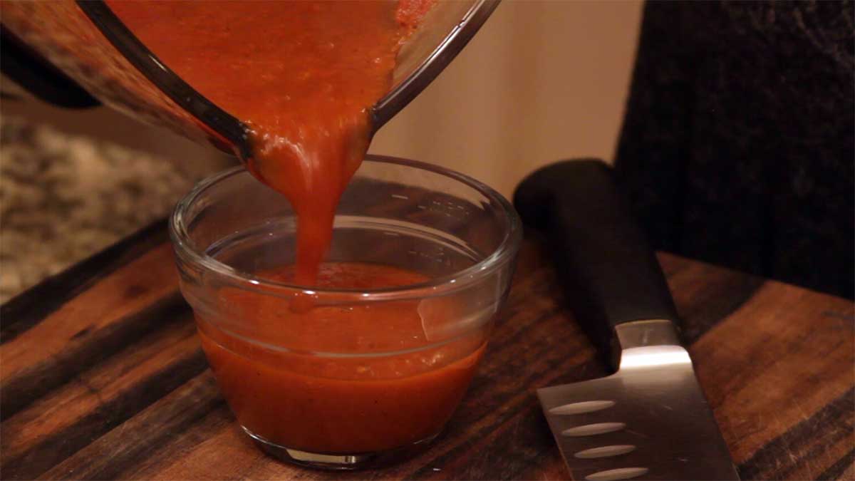 Pouring the enchilada sauce into a glass bowl