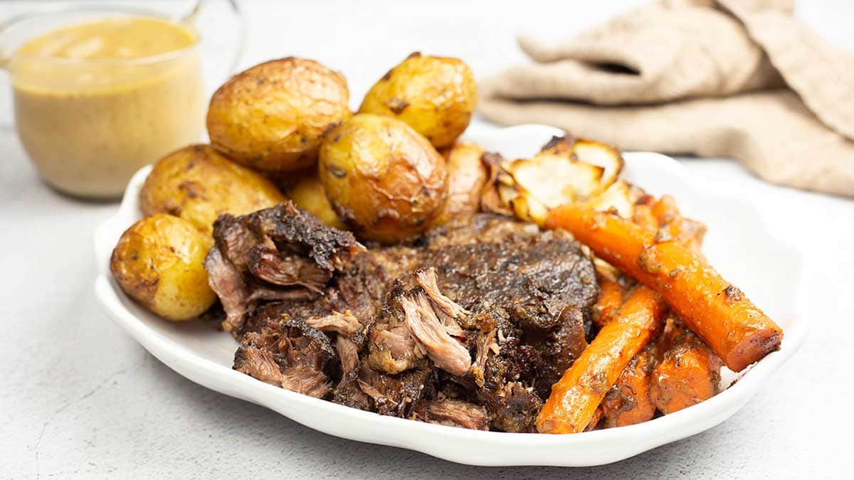 pot roast with potatoes and carrots on a white platter
