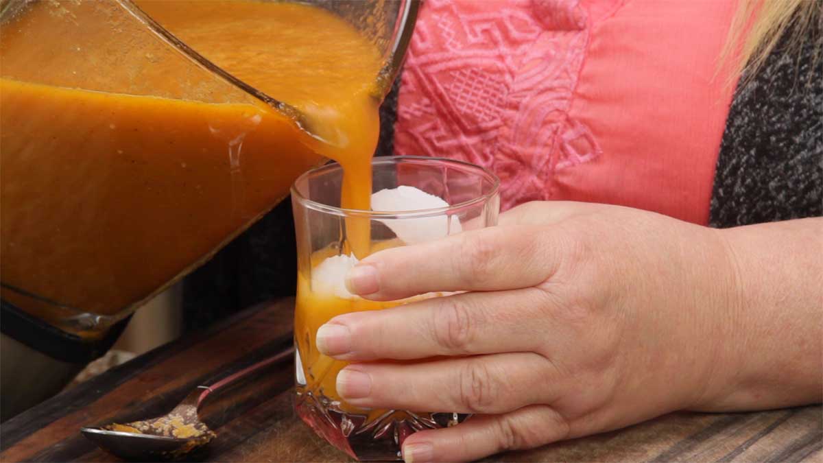 Pouring warm bloody mary mix over ice