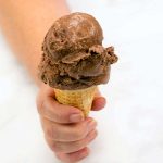 holding a chocolate ice cream cone