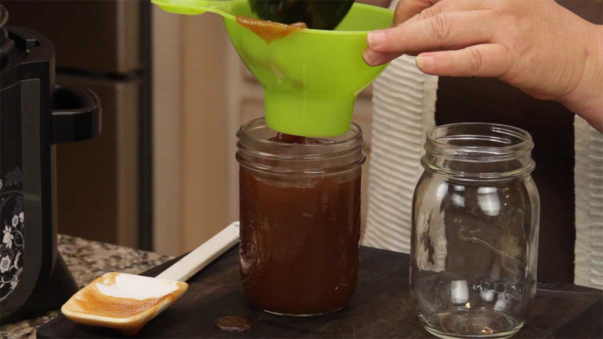 Filling glass jars with apple butter