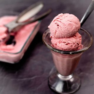 2 scoops of Homemade strawberry ice cream in a glass dish