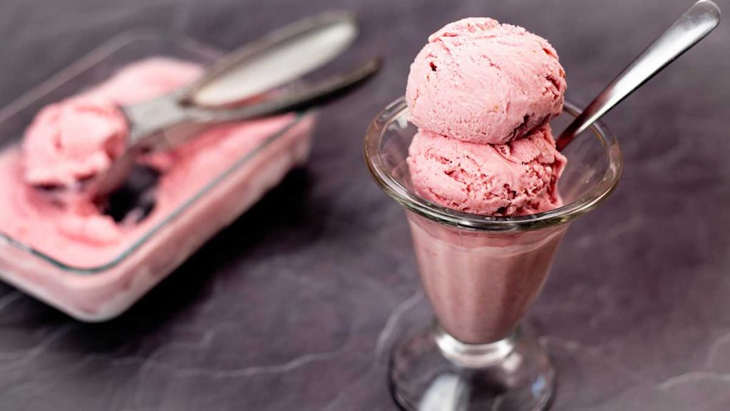 2 scoops of Homemade strawberry ice cream in a glass dish