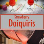 two strawberry daquiris in hurricane glasses with colored straws and drink umbrellas