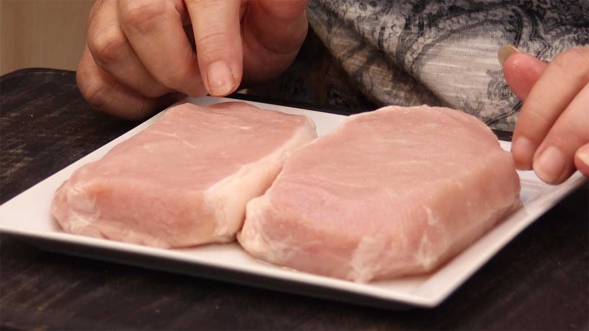 two boneless 1" pork chops on a white plate