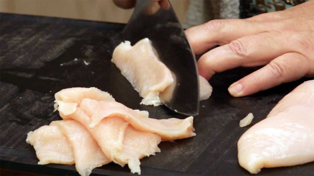 slicing chicken into thin slices