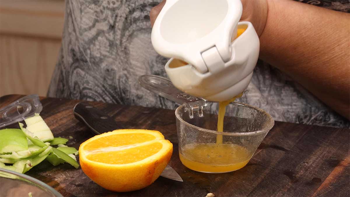 juicing the orange with a citrus press