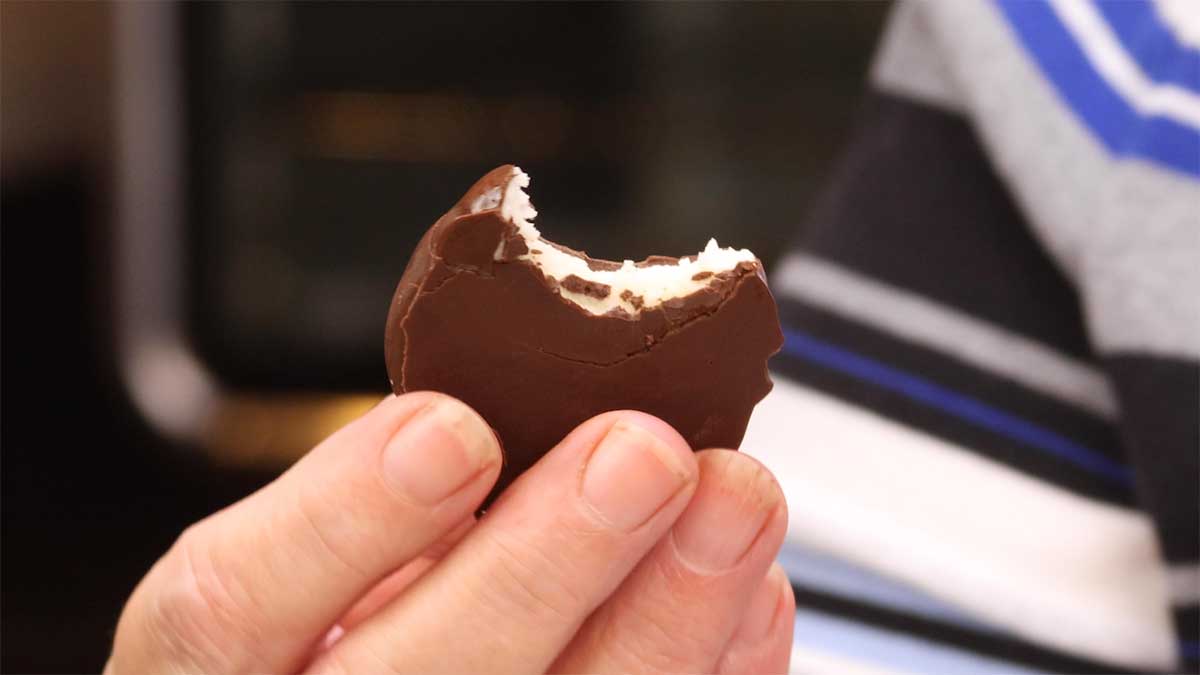 holding a peppermint patty with a bite out of it