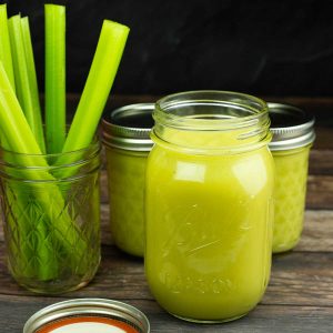 jars of condensed cream of celery soup next to a glass with celery stalks in it