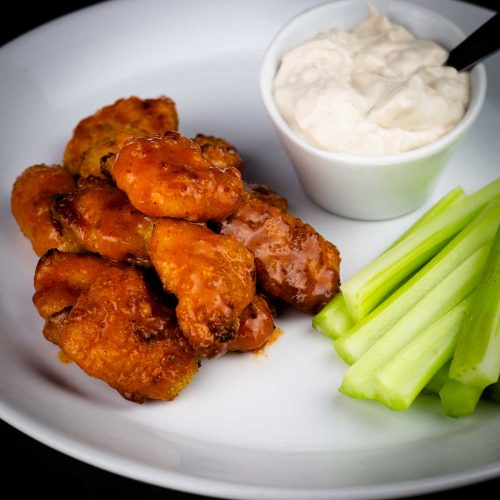 air fryer boneless wings on a plate with celery and blue cheese