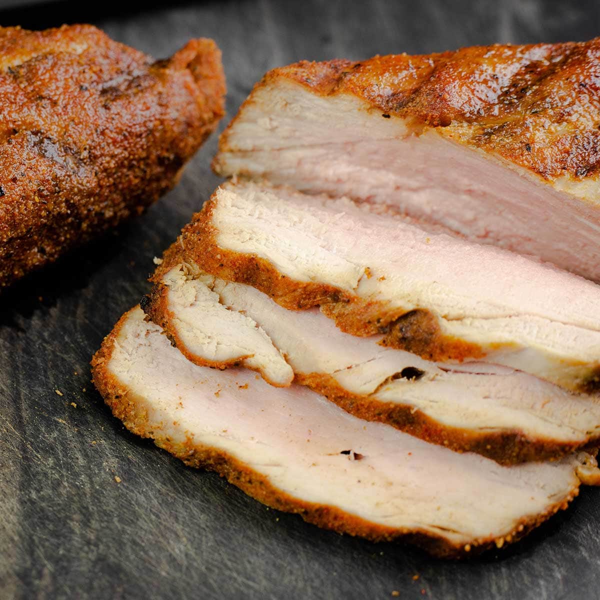 grilled pork tenderloin sliced on a cutting board
