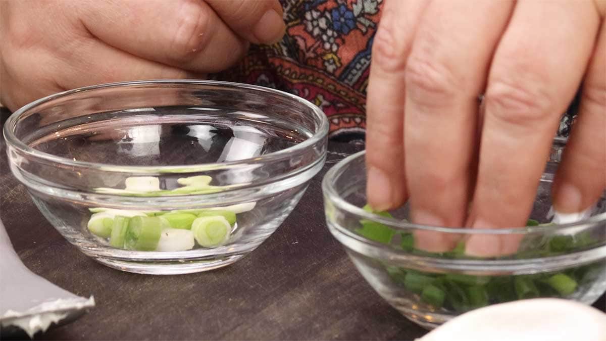 showing white part of green onion chopped in a bowl