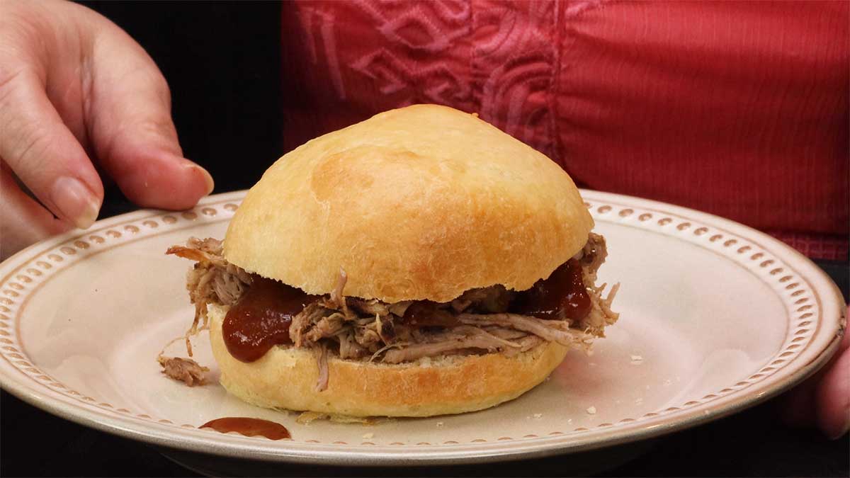 Pulled pork sandwich on a plate with bbq sauce