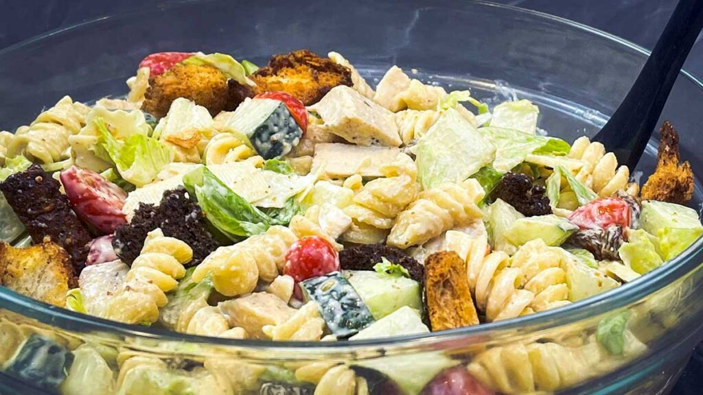 caesar pasta salad in a large glass bowl